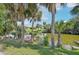Serene waterfront view with a dock, inviting outdoor seating and mature palm trees around at 3156 Depew Ave, Port Charlotte, FL 33952