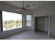 Bedroom with a ceiling fan, a closet with shelving, and a scenic waterfront view from the window at 3402 Amberjack Dr, Hernando Beach, FL 34607