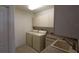 Well-equipped laundry room with washer, dryer, utility sink, and ample storage cabinets at 3402 Amberjack Dr, Hernando Beach, FL 34607