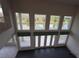 Bright living room with large windows offering scenic waterfront views and access to a balcony at 3402 Amberjack Dr, Hernando Beach, FL 34607