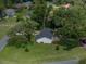 Aerial view showcases the property, mature trees, landscaping, and surrounding neighborhood at 34819 Hibiscus Dr, Dade City, FL 33523