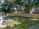Large fenced backyard with mature trees, lush grass, and a concrete patio is perfect for outdoor enjoyment at 34819 Hibiscus Dr, Dade City, FL 33523