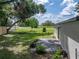 A spacious backyard featuring an open green area, a concrete patio, and chain-link fencing for privacy at 34819 Hibiscus Dr, Dade City, FL 33523