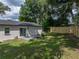 Expansive backyard featuring mature trees, lush lawn, concrete patio, and a new wooden fence for privacy at 34819 Hibiscus Dr, Dade City, FL 33523
