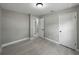 Bedroom featuring neutral walls, wood-look tile, open door to other rooms and closet, offering a modern and serene atmosphere at 34819 Hibiscus Dr, Dade City, FL 33523