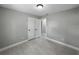 Bedroom showcasing light gray walls, wood-look tile, and an open closet, promoting spaciousness and modern style at 34819 Hibiscus Dr, Dade City, FL 33523