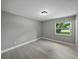 Bedroom featuring new paint, woodgrain floors, and a window overlooking the yard at 34819 Hibiscus Dr, Dade City, FL 33523