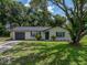 Charming painted brick home with an attached garage, manicured front yard, and mature trees at 34819 Hibiscus Dr, Dade City, FL 33523