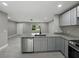 Kitchen view featuring granite countertops, stainless steel appliances, and grey cabinets at 34819 Hibiscus Dr, Dade City, FL 33523