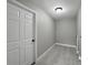 Functional laundry room with modern lighting, neutral walls, and wood-look tile flooring for a clean aesthetic at 34819 Hibiscus Dr, Dade City, FL 33523