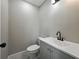Updated powder room with a light gray vanity, solid surface counter, black fixtures, and wood-look tile floors at 34819 Hibiscus Dr, Dade City, FL 33523