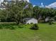 Well-maintained yard showcasing mature trees, landscaping, and the home's exterior at 34819 Hibiscus Dr, Dade City, FL 33523