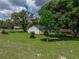 Spacious yard with lush green grass, mature trees, and manicured landscaping at 34819 Hibiscus Dr, Dade City, FL 33523