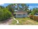 Charming single story home with light-grey exterior, well-maintained landscaping, and a beautiful, mature shade tree at 3544 6Th S Ave, St Petersburg, FL 33711