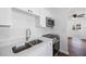 Modern kitchen with stainless appliances, double basin sink, and white cabinets at 3544 6Th S Ave, St Petersburg, FL 33711