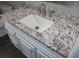 Granite countertop vanity with white cabinets in renovated bathroom at 38668 Ferm Cir, Zephyrhills, FL 33540
