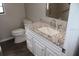 Bathroom with a white vanity and granite countertop, toilet and tiled shower at 38668 Ferm Cir, Zephyrhills, FL 33540