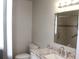 Bathroom with a white vanity and granite countertop, toilet and tiled shower at 38668 Ferm Cir, Zephyrhills, FL 33540