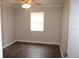 Cozy bedroom featuring hardwood floors, a ceiling fan, and a bright window at 38668 Ferm Cir, Zephyrhills, FL 33540