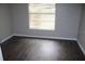Comfortable bedroom with neutral walls, dark wood-look floors and a large window at 38668 Ferm Cir, Zephyrhills, FL 33540