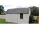 White storage shed in a fenced backyard at 38668 Ferm Cir, Zephyrhills, FL 33540