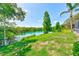 View of the home's backyard leading to a lake, with foliage and trees at 4008 Moreland Dr, Valrico, FL 33596