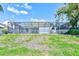 View of the home's backyard with a screened-in porch and green lawn at 4008 Moreland Dr, Valrico, FL 33596