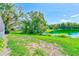 View of the home's backyard with a lake and green trees in the background at 4008 Moreland Dr, Valrico, FL 33596