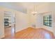 Bright dining room features wood floors, a modern chandelier, and a large window for natural light at 4008 Moreland Dr, Valrico, FL 33596
