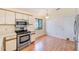 Bright kitchen features white cabinets, stainless steel appliances and wood-look flooring at 4008 Moreland Dr, Valrico, FL 33596