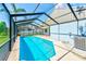 Screened-in pool with sunny blue water, a palm tree and an adjacent outdoor air conditioning unit at 4008 Moreland Dr, Valrico, FL 33596