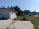 View of the home's rear exterior and backyard featuring a concrete patio area and lush greenery at 4802 Drift Tide Dr, New Port Richey, FL 34652