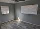 A bright, neutrally decorated bedroom featuring wood-look flooring and a ceiling fan at 4802 Drift Tide Dr, New Port Richey, FL 34652