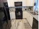 Well-lit kitchen showcasing white cabinets, black appliances, and tile backsplash at 4802 Drift Tide Dr, New Port Richey, FL 34652