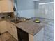 Updated kitchen with stainless steel sink, gray countertop, and white wainscoting at 4802 Drift Tide Dr, New Port Richey, FL 34652