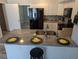 Bright kitchen features a gray countertop island, white cabinets, and black appliances at 4802 Drift Tide Dr, New Port Richey, FL 34652