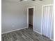 An open room with wood-look flooring, fresh paint, and bead board trim accenting the lower walls at 4802 Drift Tide Dr, New Port Richey, FL 34652