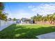 Expansive backyard featuring a lush lawn, complemented by a charming home and a well-maintained white fence at 487 49Th N Ave, St Petersburg, FL 33703
