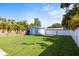Spacious, verdant backyard includes a detached garage and additional parking, bordered by mature trees and fencing at 487 49Th N Ave, St Petersburg, FL 33703