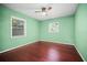 Bright bedroom featuring hardwood floors, a ceiling fan, and natural light from two windows at 487 49Th N Ave, St Petersburg, FL 33703