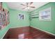 Bedroom with hardwood floors, a ceiling fan, and natural light from windows at 487 49Th N Ave, St Petersburg, FL 33703