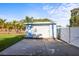 Detached garage with ample parking space, set against a backdrop of lush greenery and secure fencing at 487 49Th N Ave, St Petersburg, FL 33703