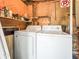 Dedicated laundry area featuring side-by-side washer and dryer, with shelving for storage and organization at 487 49Th N Ave, St Petersburg, FL 33703