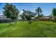 Expansive backyard with lush green grass, mature trees, and an outdoor seating area perfect for entertaining at 509 N Washington Ave, Clearwater, FL 33755