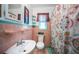 Quaint bathroom with unique pink and teal tile, vintage fixtures, and a patterned shower curtain at 509 N Washington Ave, Clearwater, FL 33755