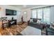 Cozy living room with wood-look floors, gray sofas, and bright natural light streaming through the window at 509 N Washington Ave, Clearwater, FL 33755