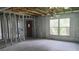 Interior space mid-renovation, featuring exposed framing, original ceilings fan, and a large window at 5540 Cyril Dr, Dade City, FL 33523
