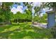 Backyard with lush green grass, seating area, fire pit, and mature trees at 5840 39Th N St, St Petersburg, FL 33714