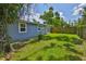 Charming backyard featuring lush green grass, privacy fence, and mature trees at 5840 39Th N St, St Petersburg, FL 33714