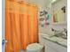 Bright bathroom features a white vanity, modern fixtures and an orange shower curtain for a vibrant feel at 5840 39Th N St, St Petersburg, FL 33714